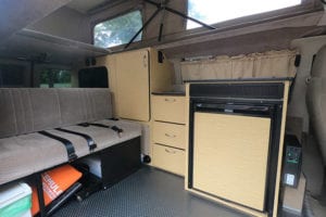 Inside 4wd Ford Econoline camper van conversion with kitchen and sofa bed