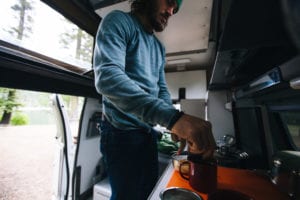 Making coffee in a van while road tripping through Oregon
