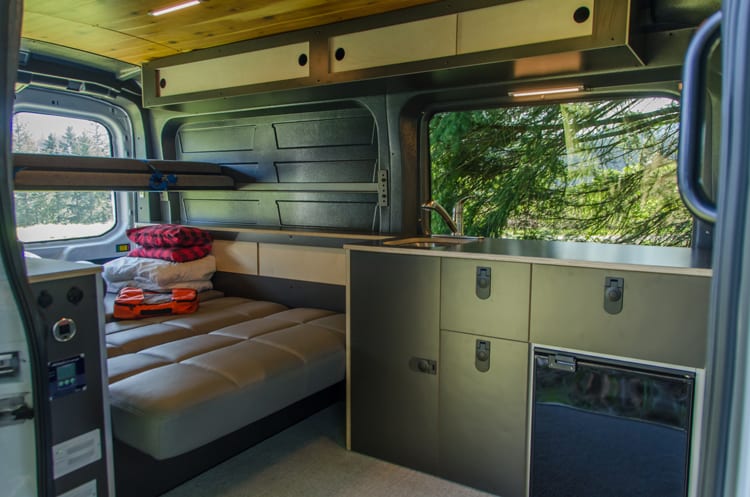Interior kitchen, storage and beds in a Ford Transit Campervan built by Axis Vehicle Outfitters in Portland, Oregon