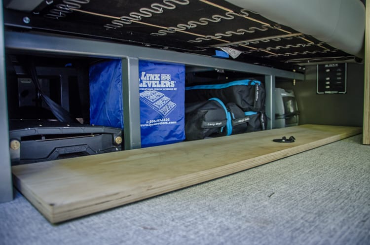 Interior storage under sofa bed in a Ford Transit Campervan built by Axis Vehicle Outfitters in Portland, Oregon