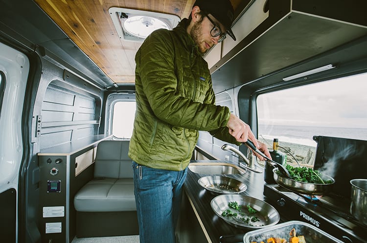 Cooking dinner in a Ford Transit Campervan built by Axis Vehicle Outfitters in Portland, Oregon