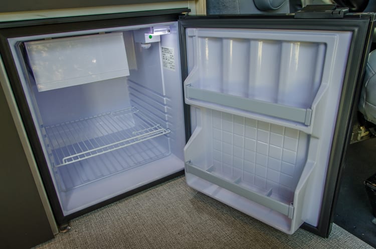 Interior kitchen fridge in a Ford Transit Campervan built by Axis Vehicle Outfitters in Portland, Oregon