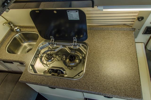 Kitchen and stove of a 2011 2wd Ford Econoline Sportsmobile campervan for sale in Portland, Oregon through Roamerica camper van rental company