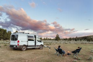 Roamerica converted campervan Ford Transit in Oregon High Desert road trip and chopping wood