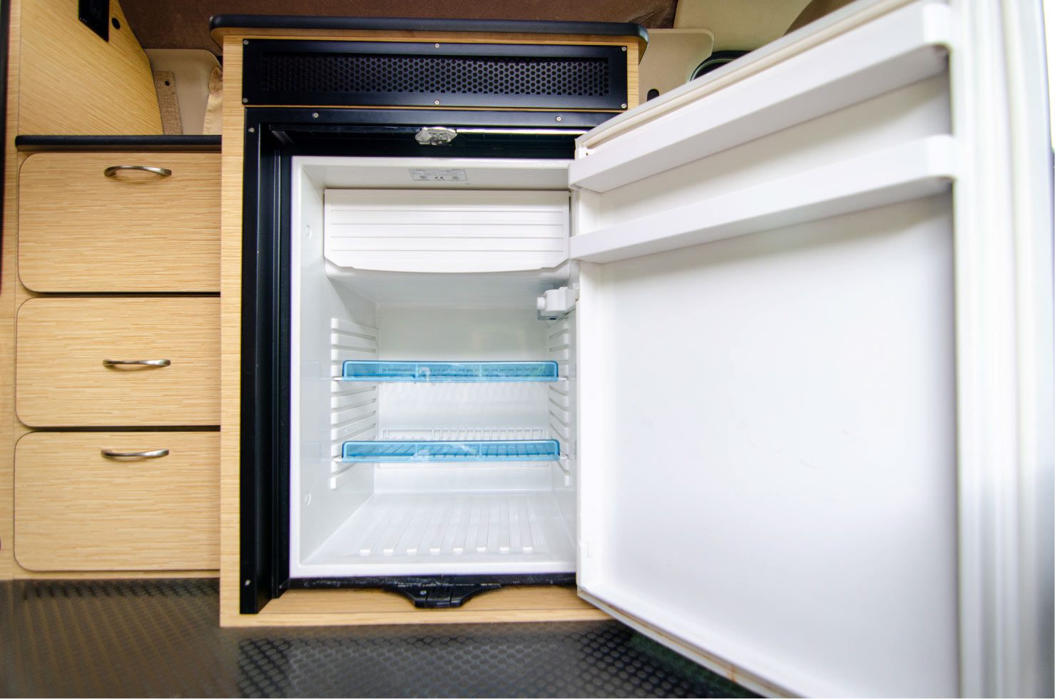 Large fridge inside a Ford E-Series 4x4 Econoline Sportsmobile RB50 Layout Campervan conversion for sale